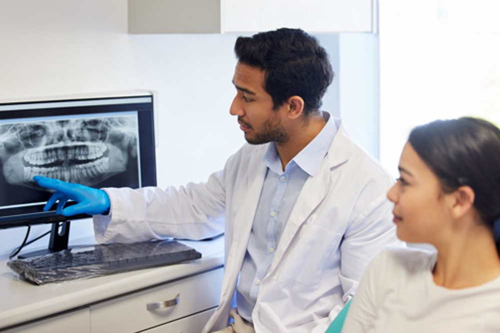 Dentist speaking with an adult patient about an urgent dental concern